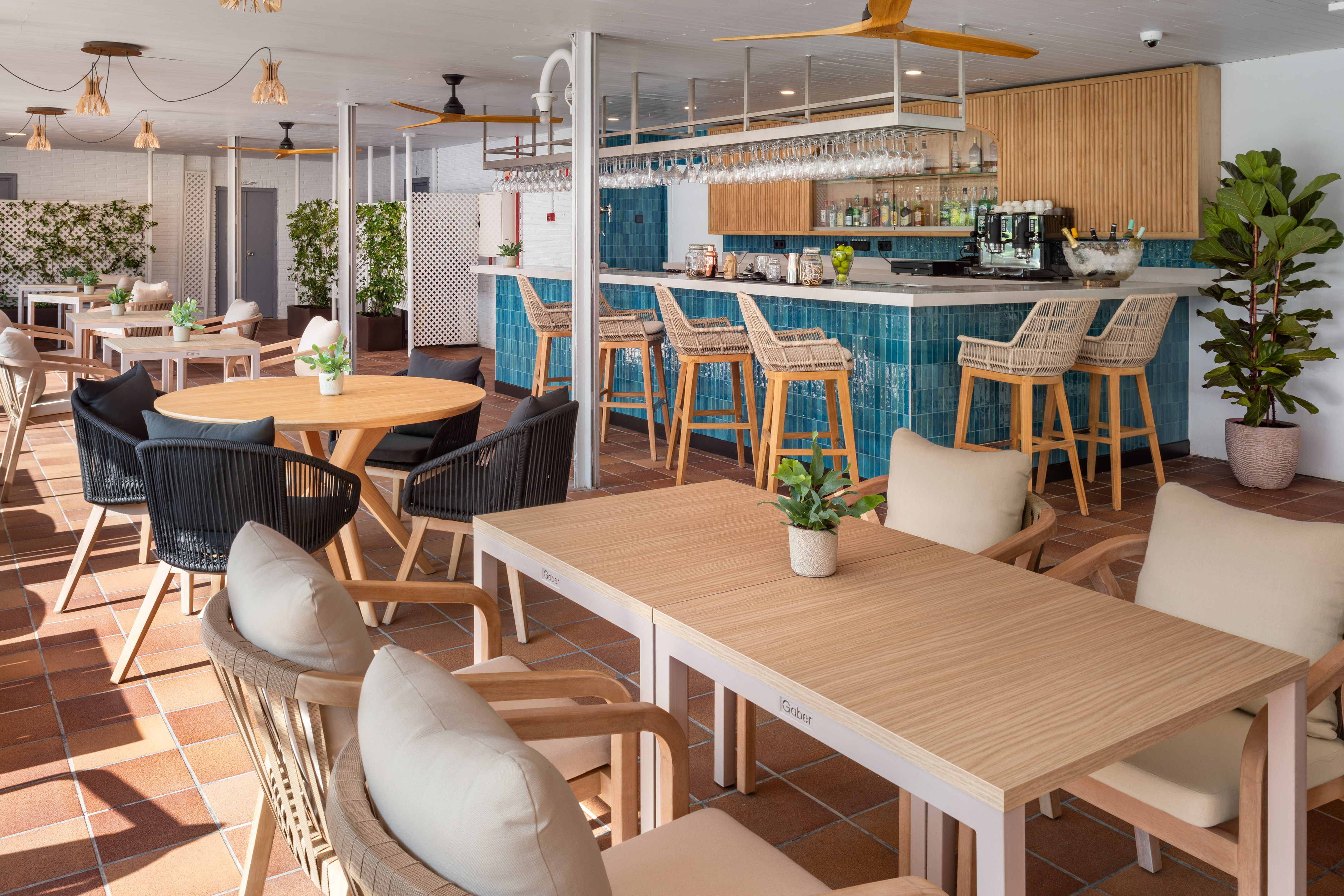 Modern resort patio bar and dining area with blue tile and wooden furniture. - Meliá Madrid Barajas, Madri