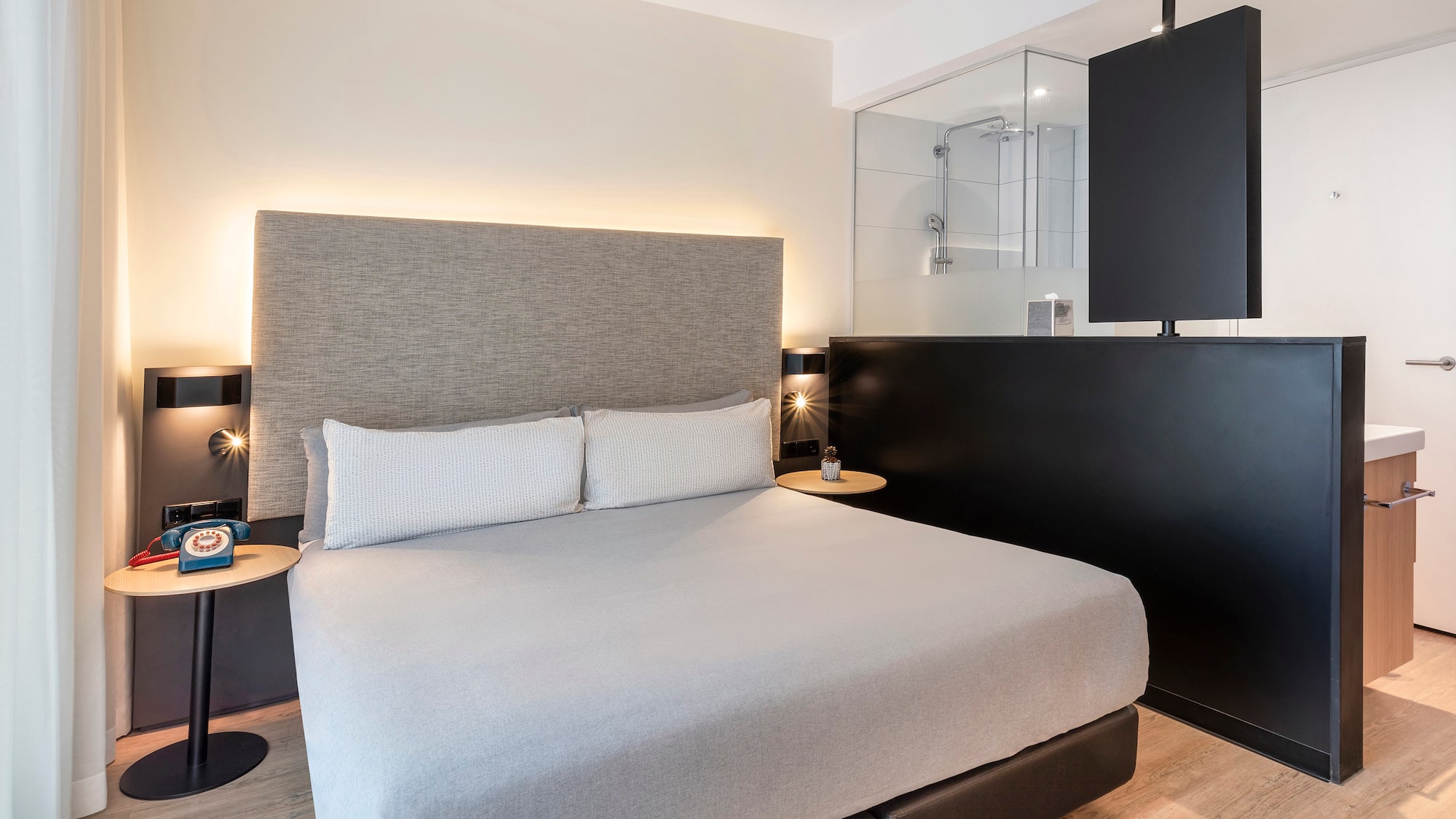 a bed with a black headboard and a black wall