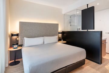 a bed with a black headboard and a black wall