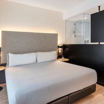 a bed with a black headboard and a black wall