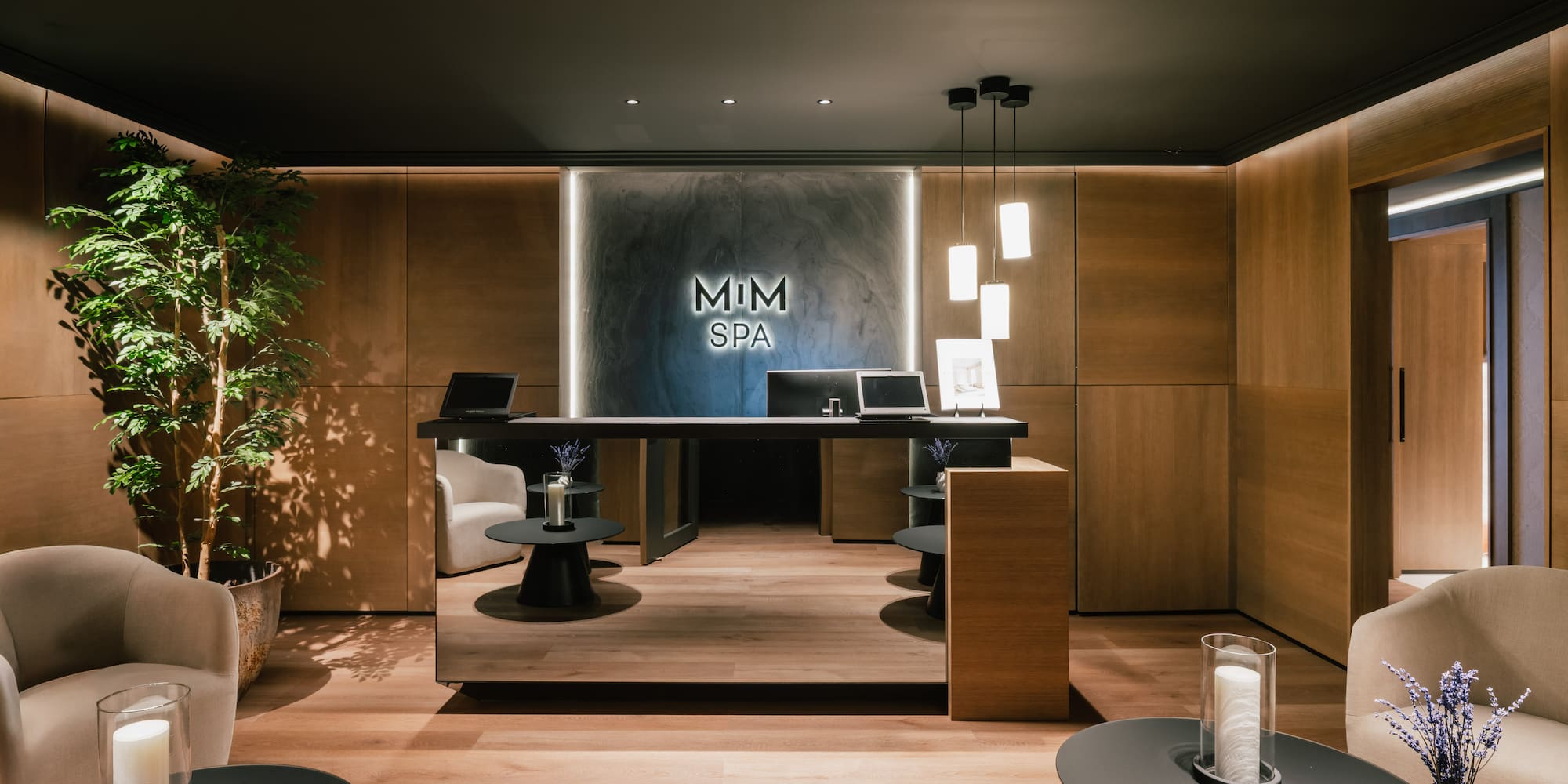 Sleek MIM SPA reception desk, wood walls, comfortable seating, and soft lighting.