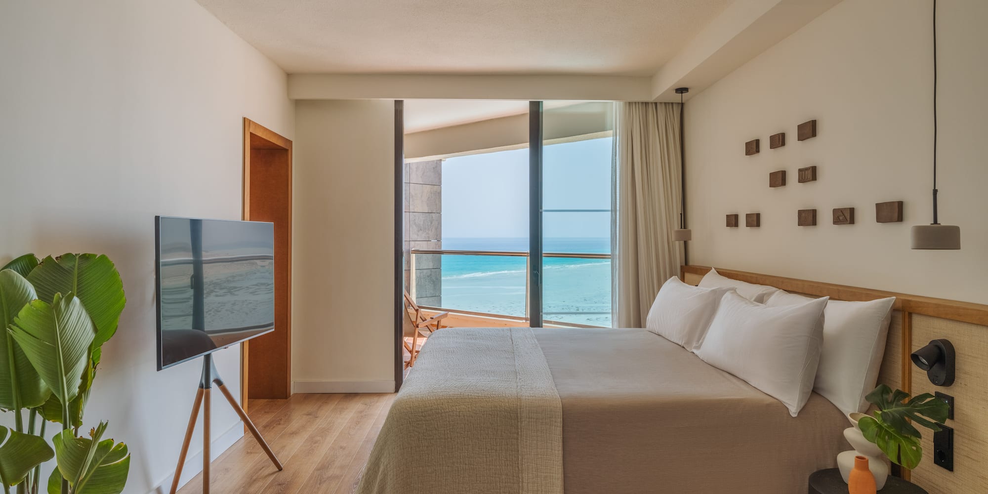 a bedroom with a television and a large window