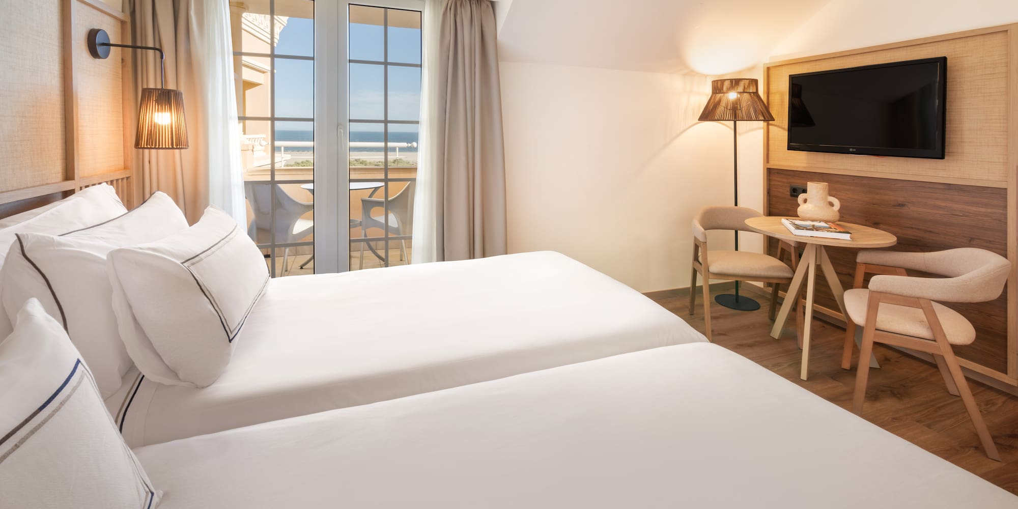 a room with two beds and a table and chairs