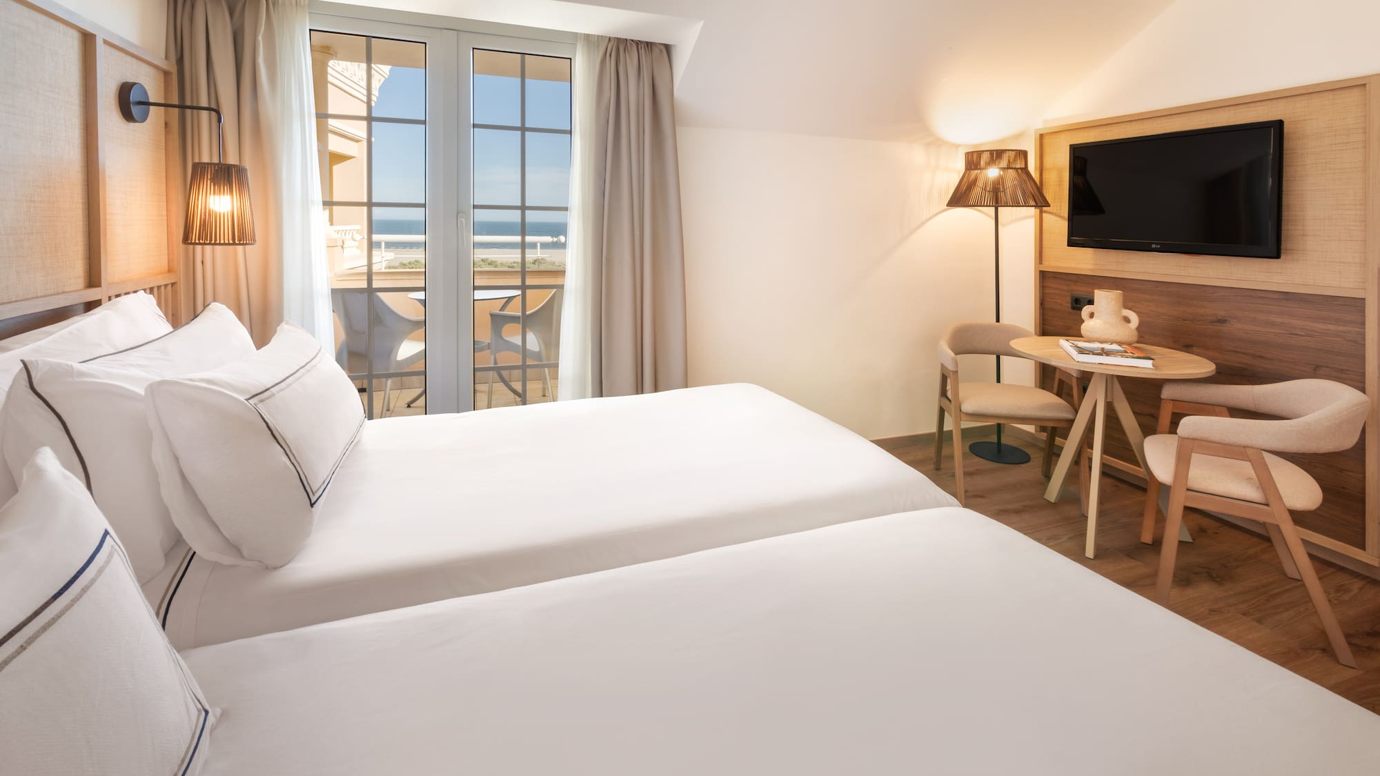 a room with two beds and a table and chairs