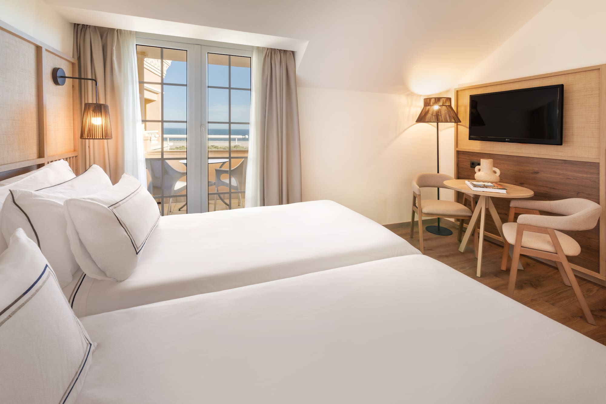 a room with two beds and a table and chairs