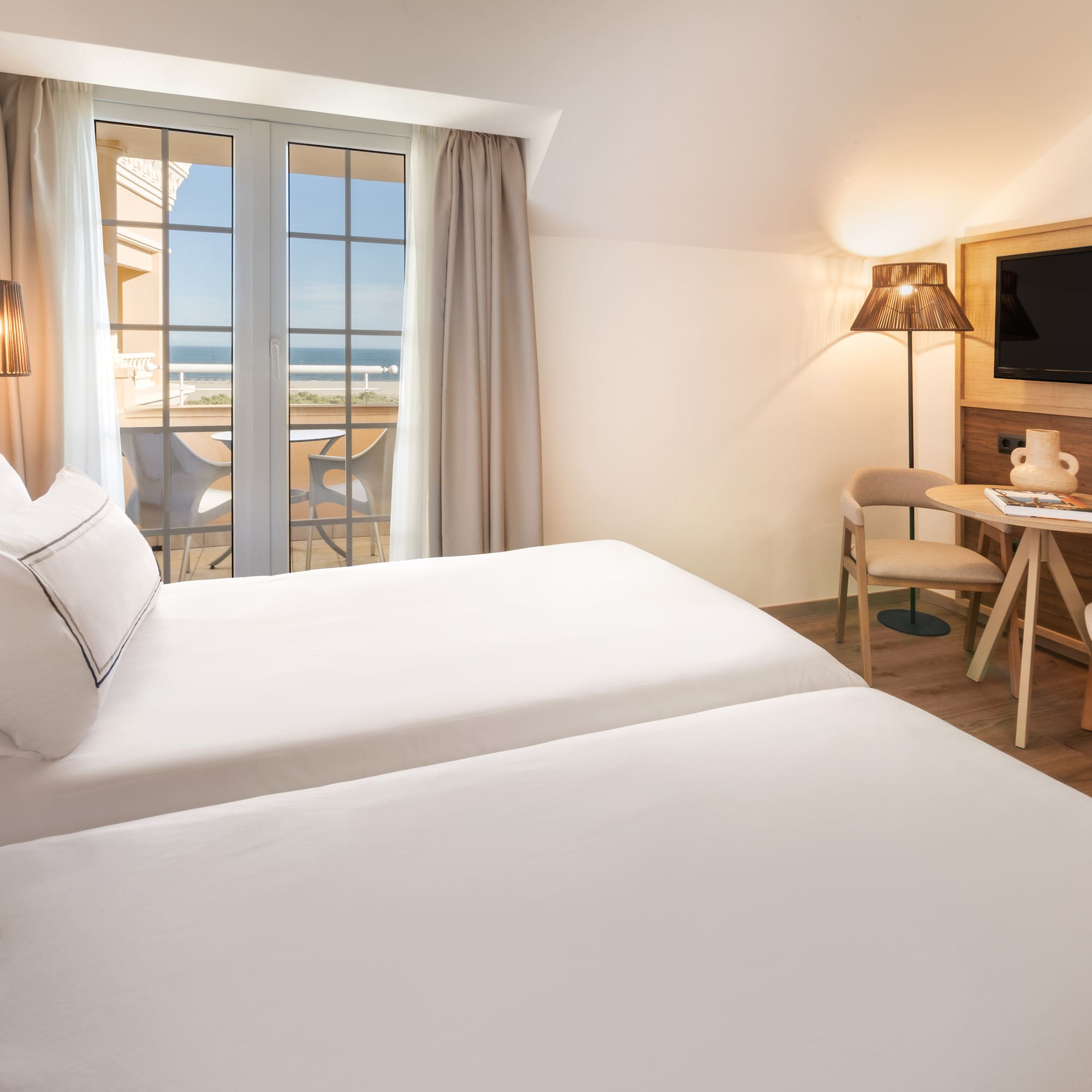 a room with two beds and a table and chairs