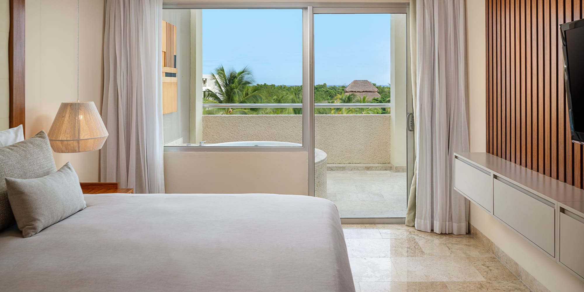 a bedroom with a glass door and a bed