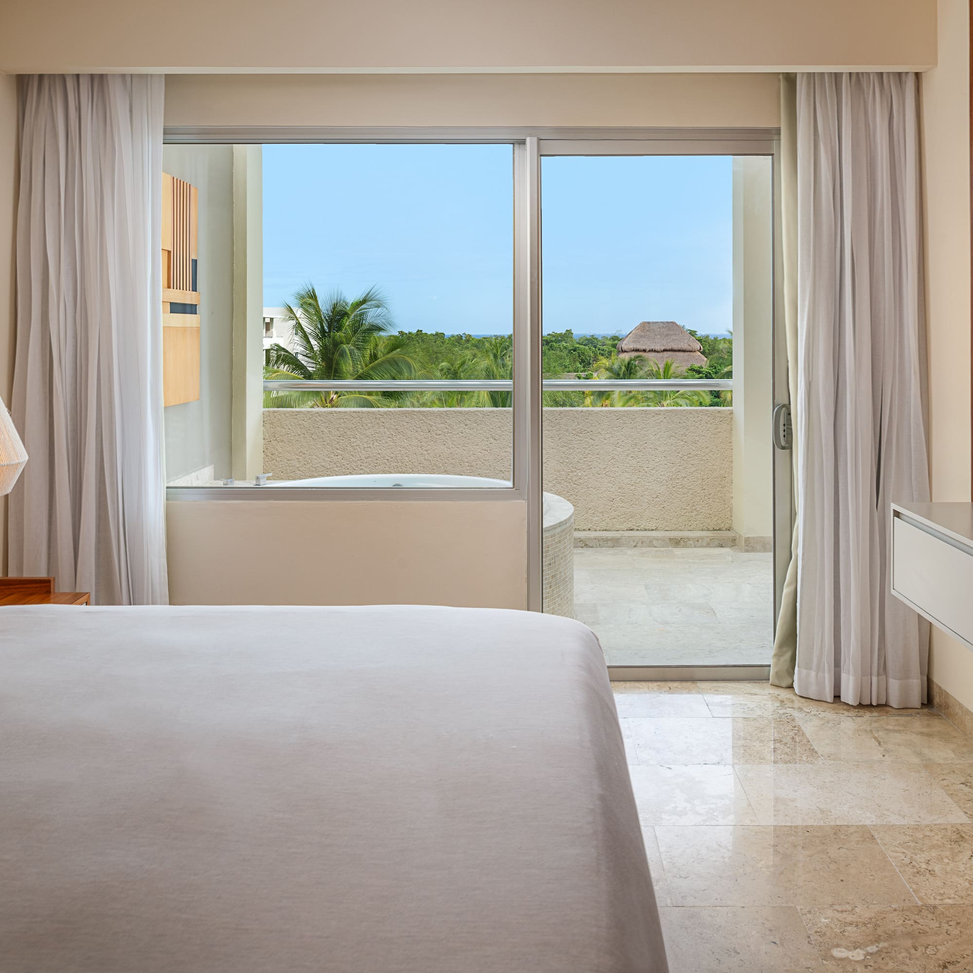 a bedroom with a glass door and a bed