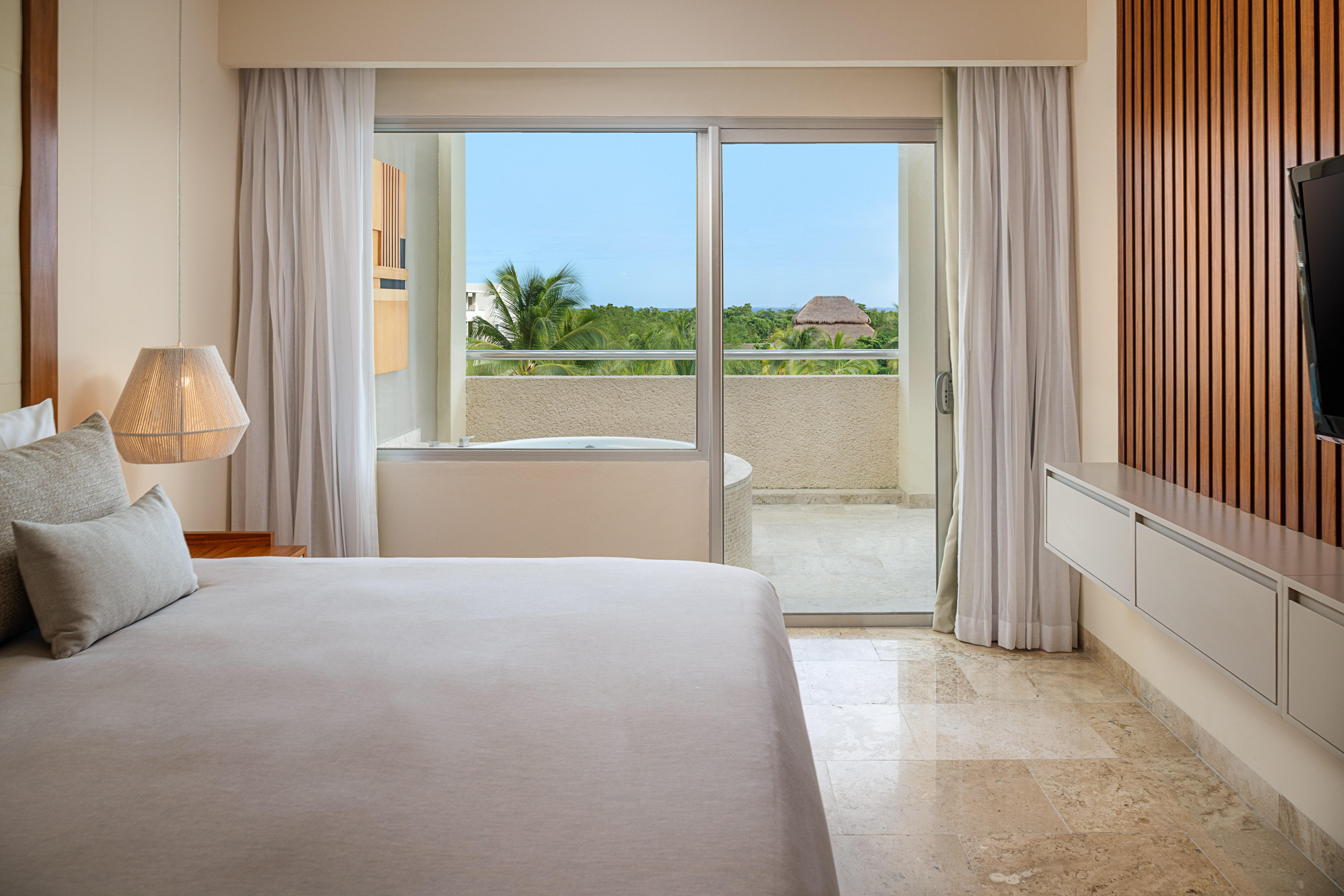 a bedroom with a glass door and a bed