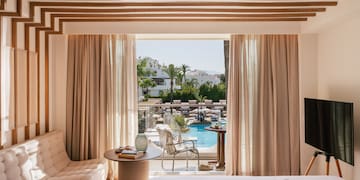 a room with a bed and a television and pool