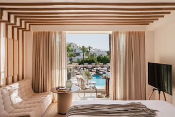 a room with a bed and a television and pool