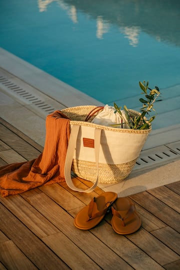 a bag and sandals next to a pool