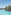 Luxury infinity pool, ocean view, palm trees, and resort building.