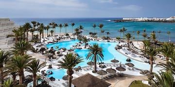 a swimming pool with palm trees and a beach