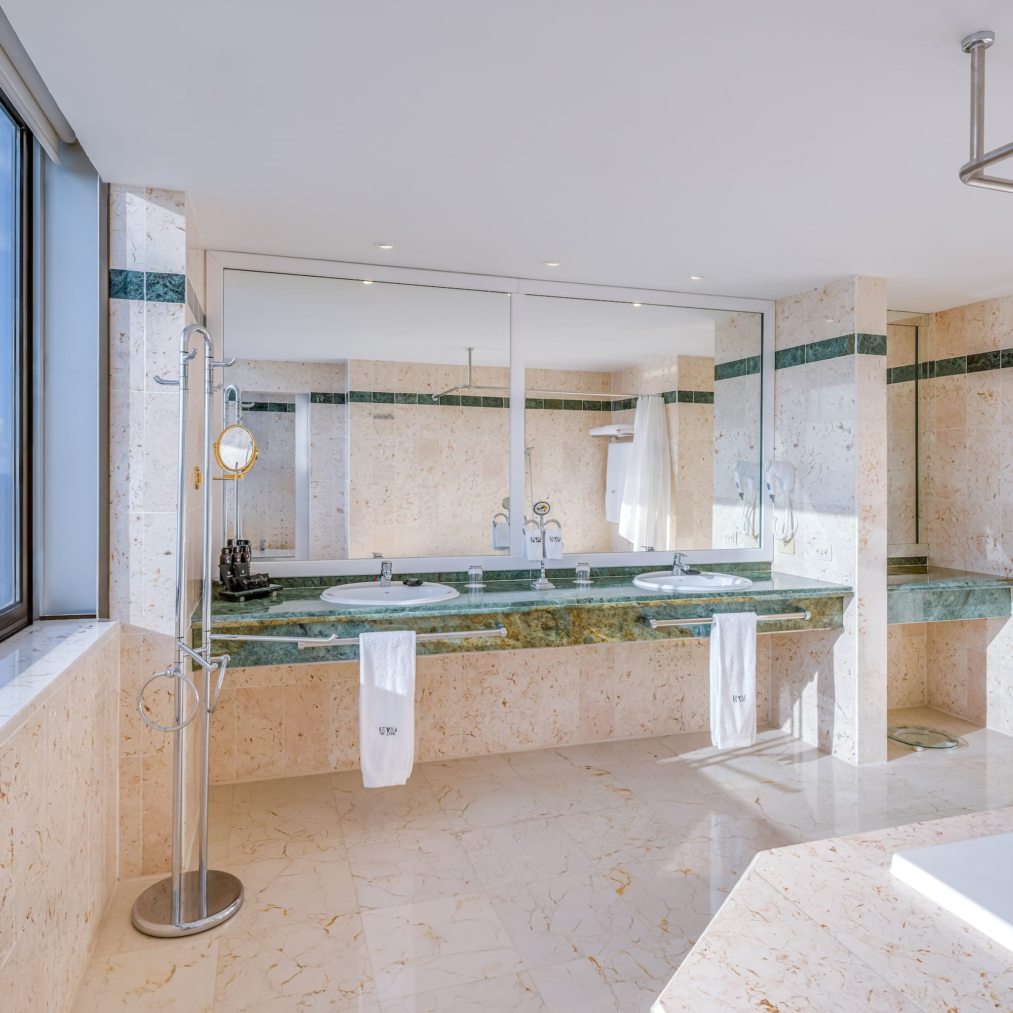 a bathroom with marble countertops and a large mirror