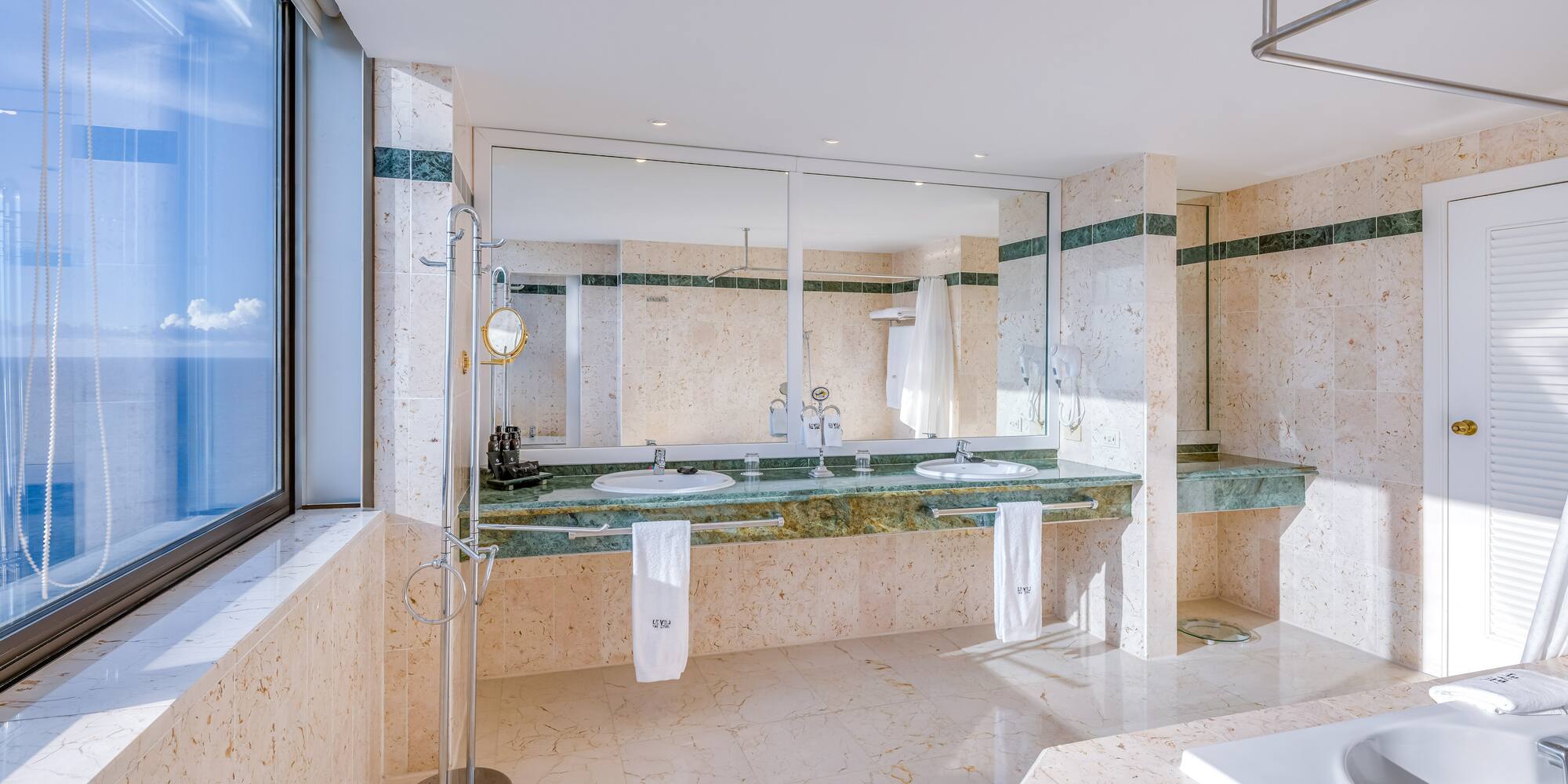 a bathroom with marble countertops and a large mirror