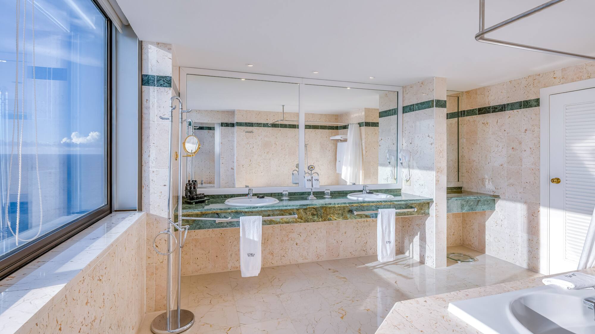 a bathroom with marble countertops and a large mirror