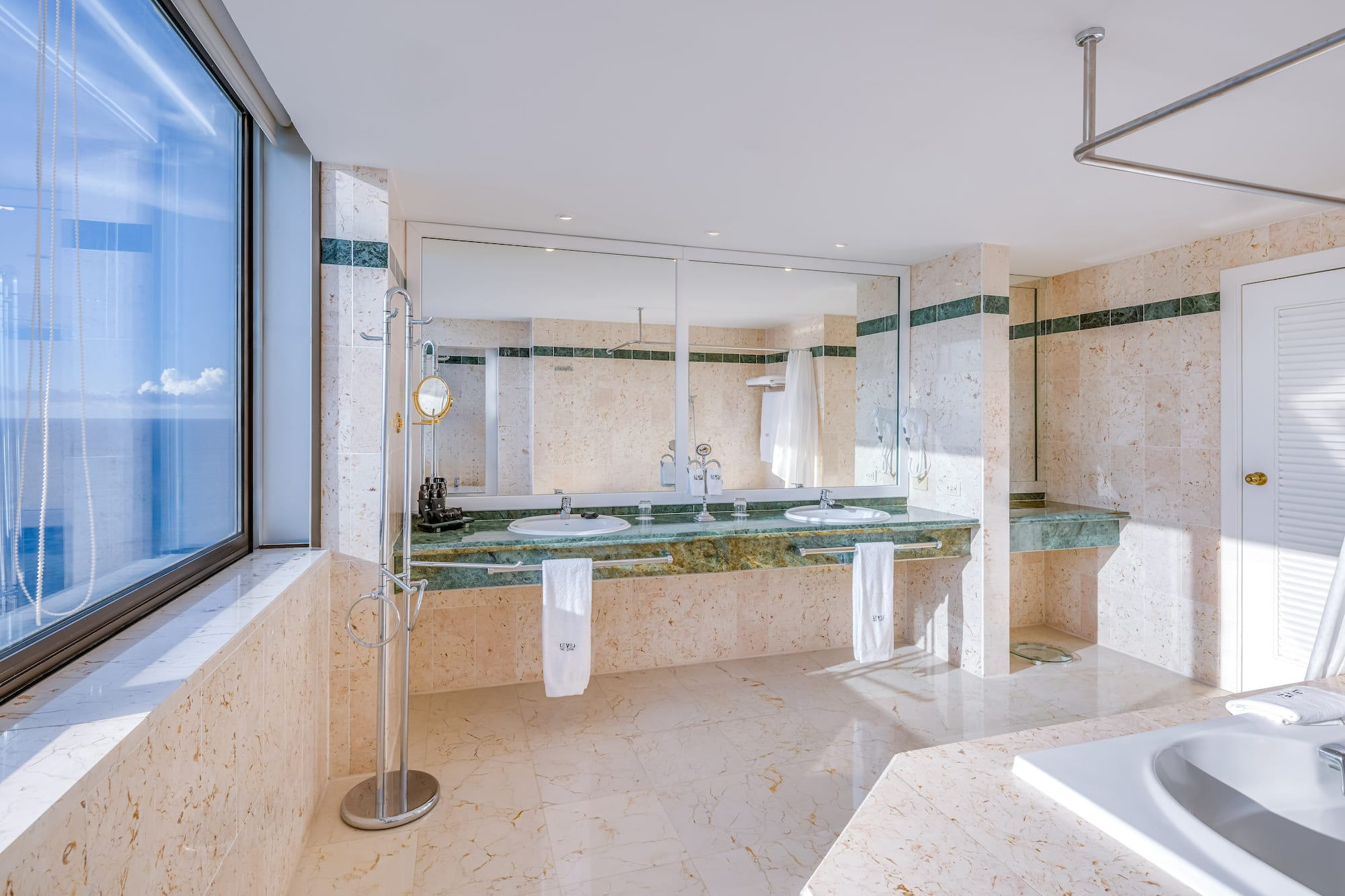 a bathroom with marble countertops and a large mirror