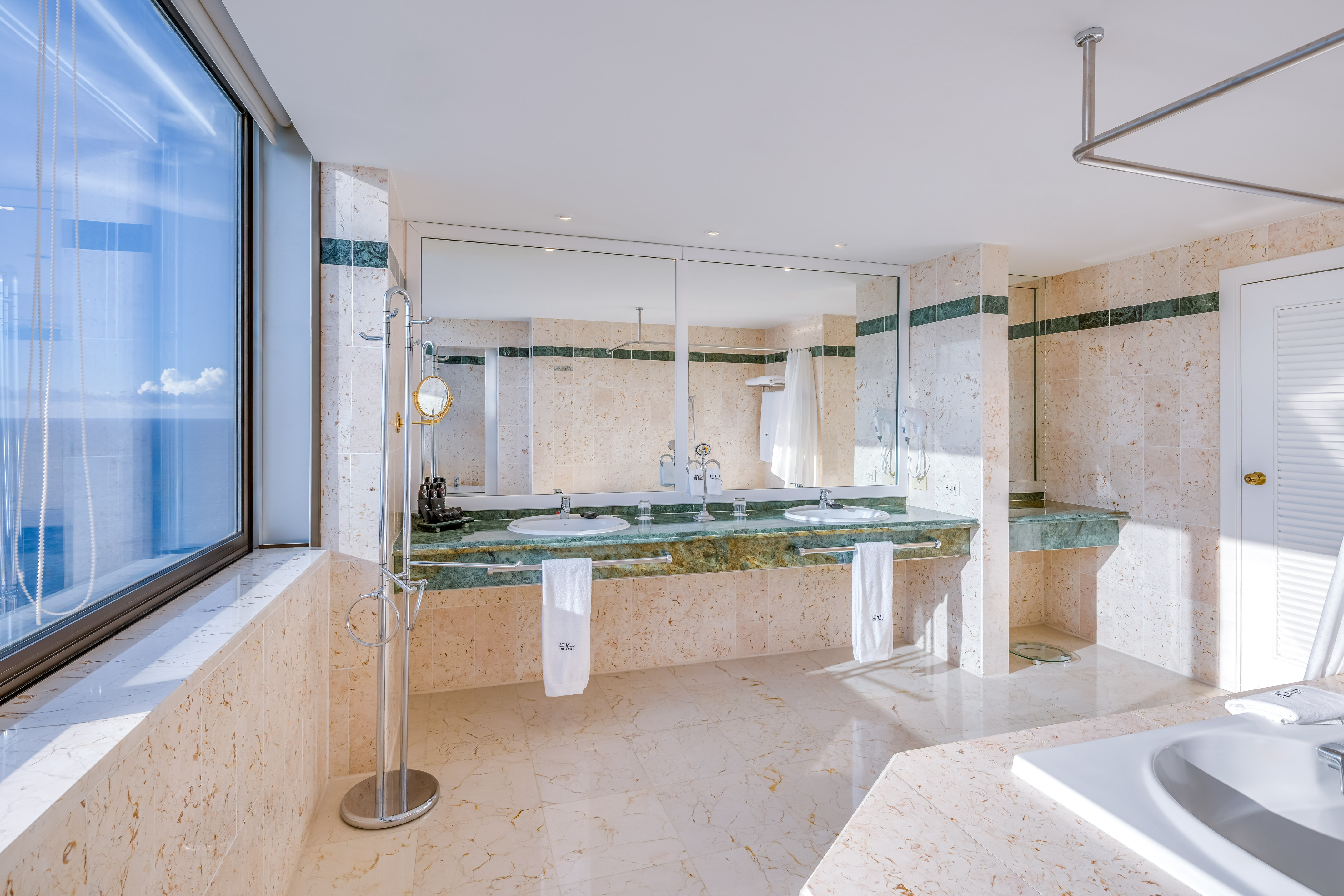a bathroom with marble countertops and a large mirror