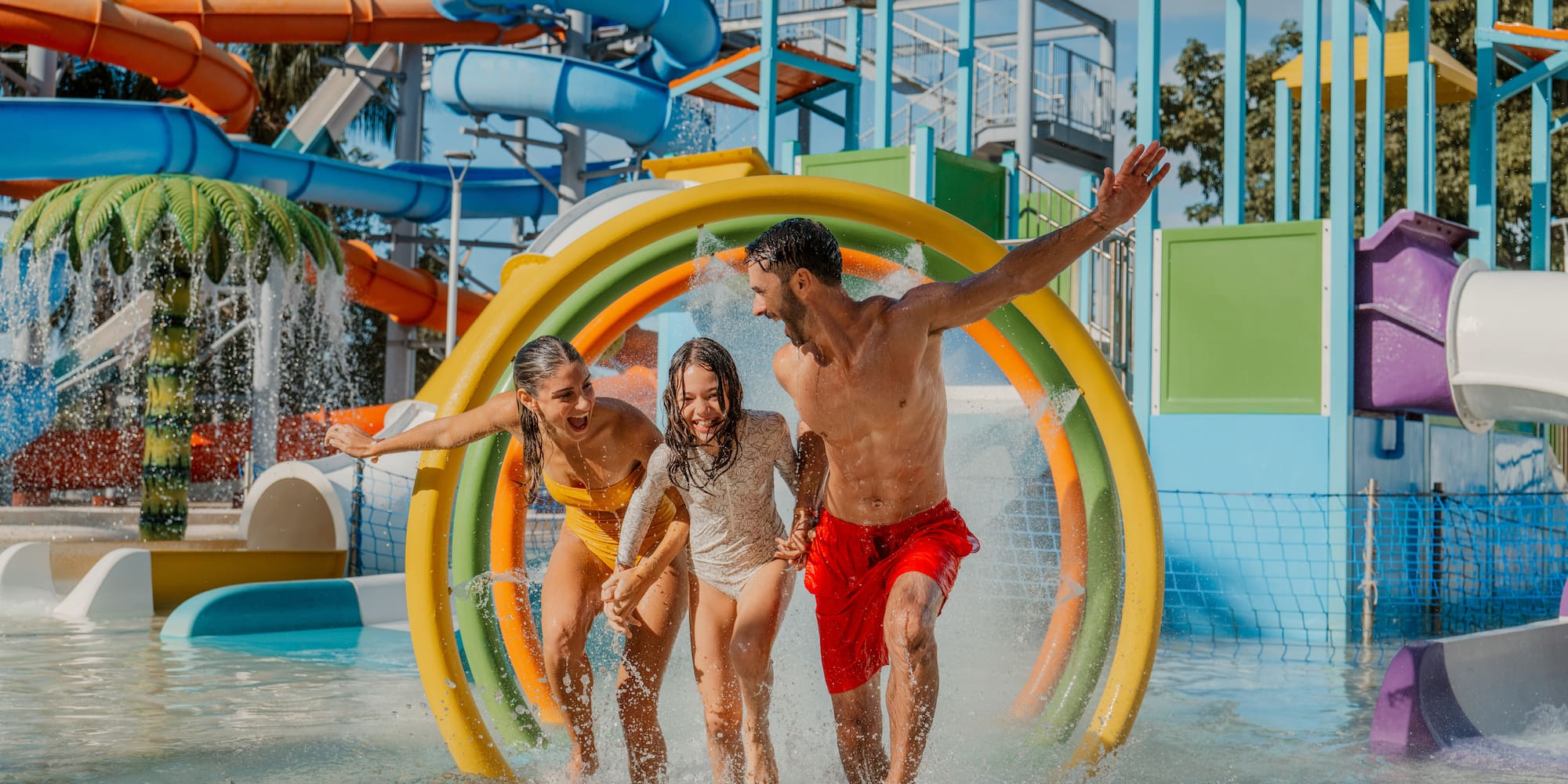a group of people running through a water park