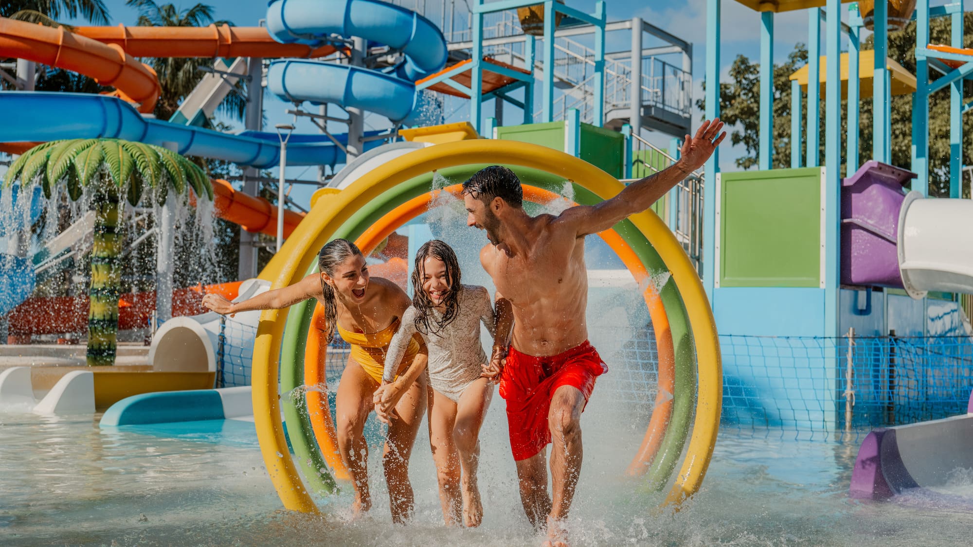 a group of people running through a water park