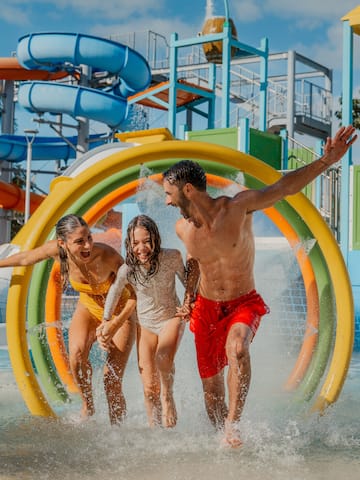 a group of people running through a water park