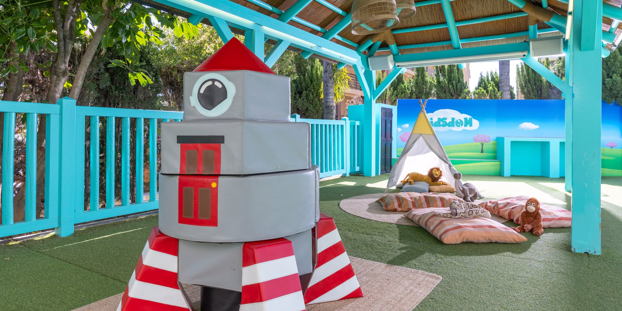 Children's soft play club with rocket, teepee, and vibrant nature mural.