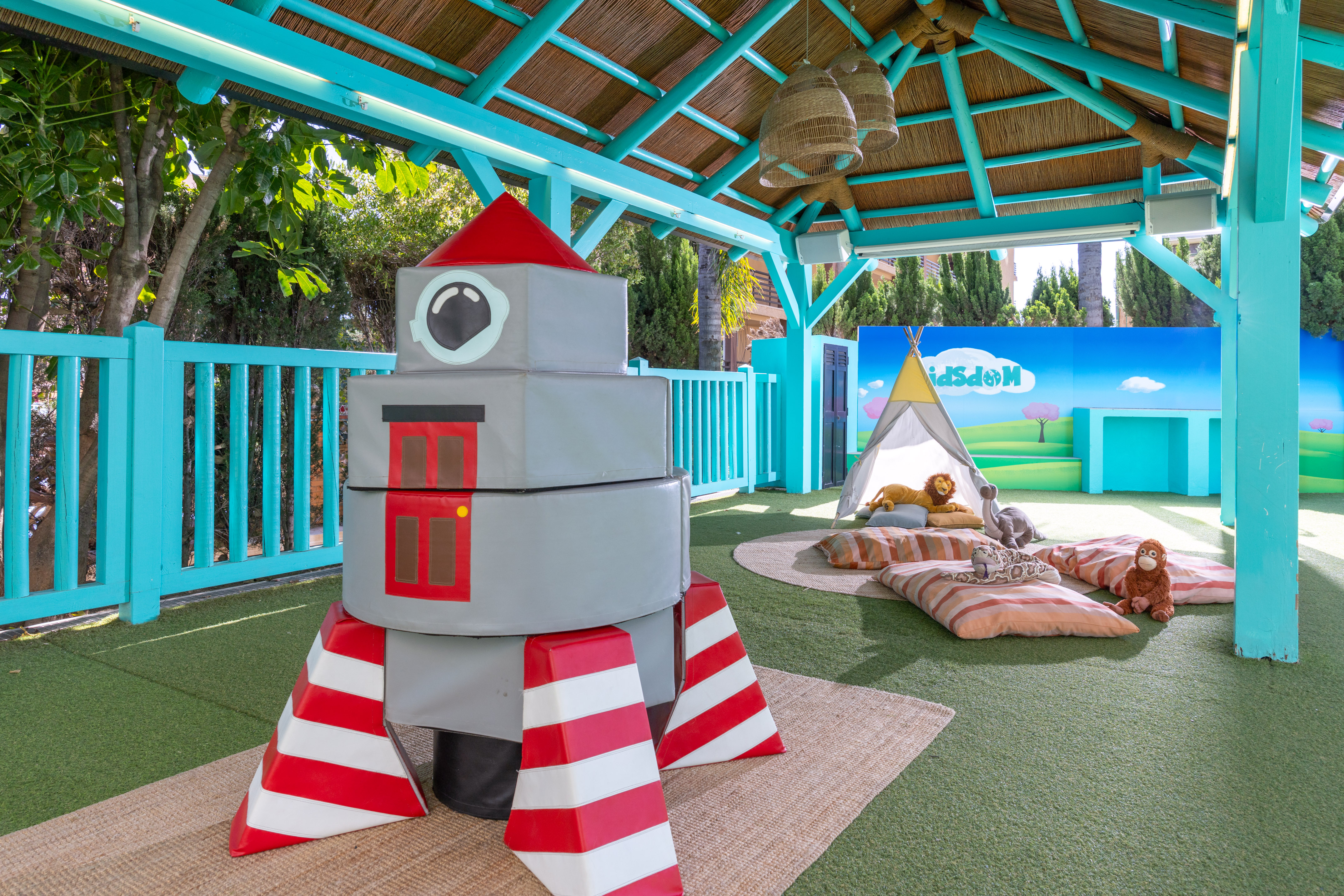 Children's soft play club with rocket, teepee, and vibrant nature mural.