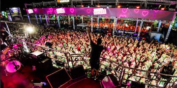 a man standing on a stage with a crowd of people in the background