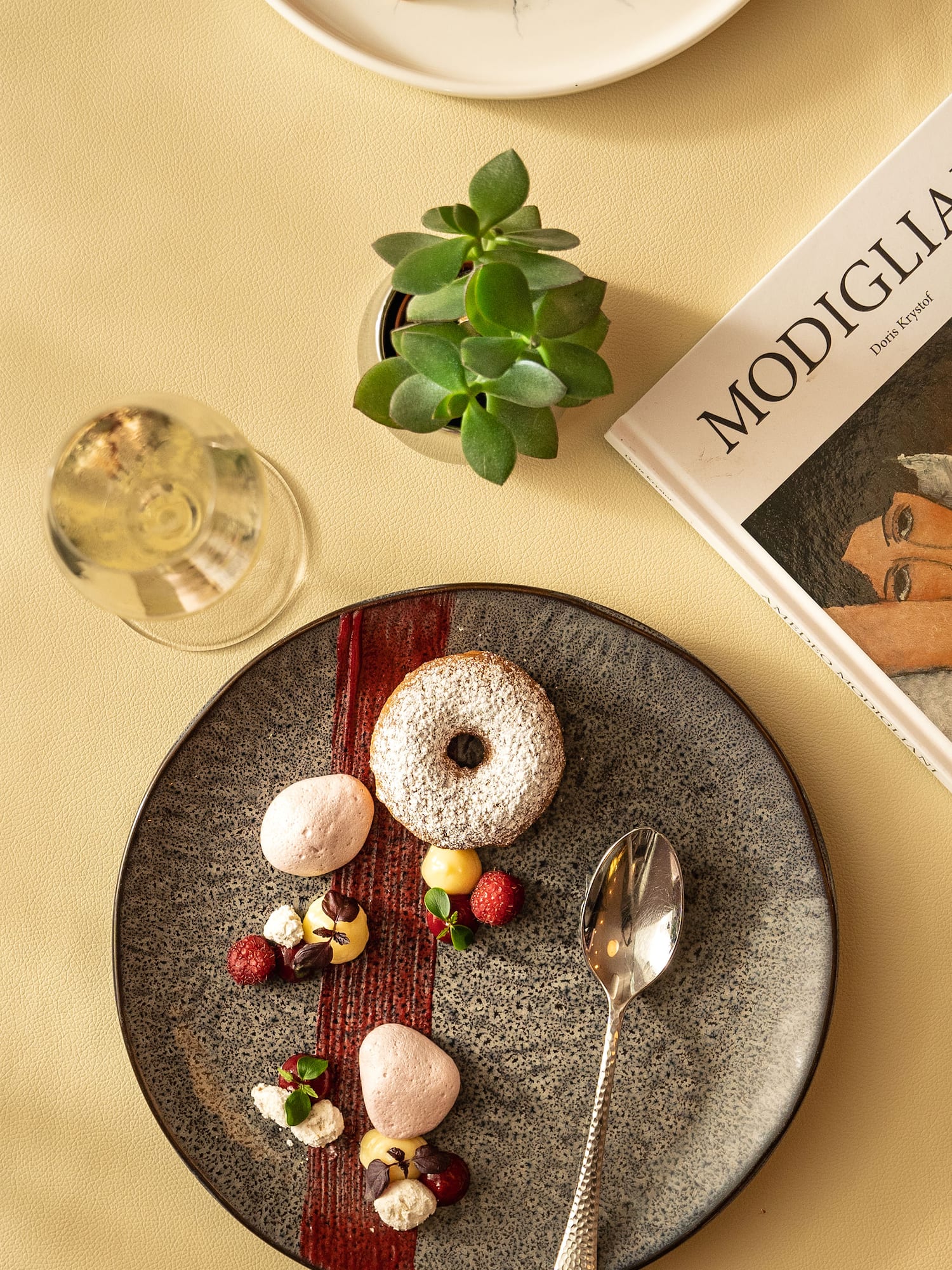 Fine dining powdered donut dessert, raspberries, meringues, wine, succulent.