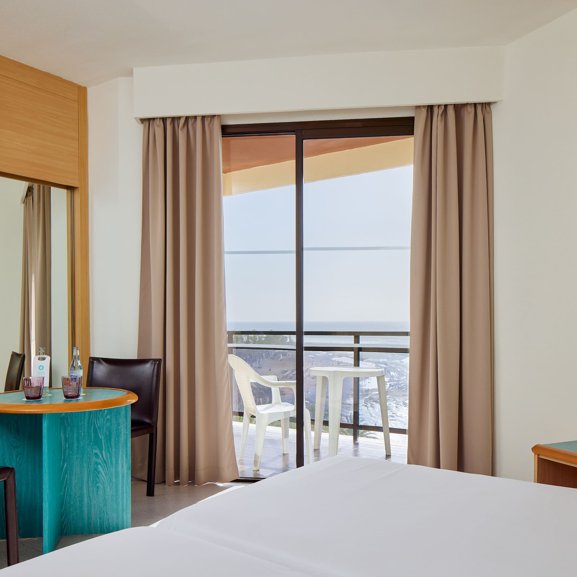 a room with a bed and a table and chairs