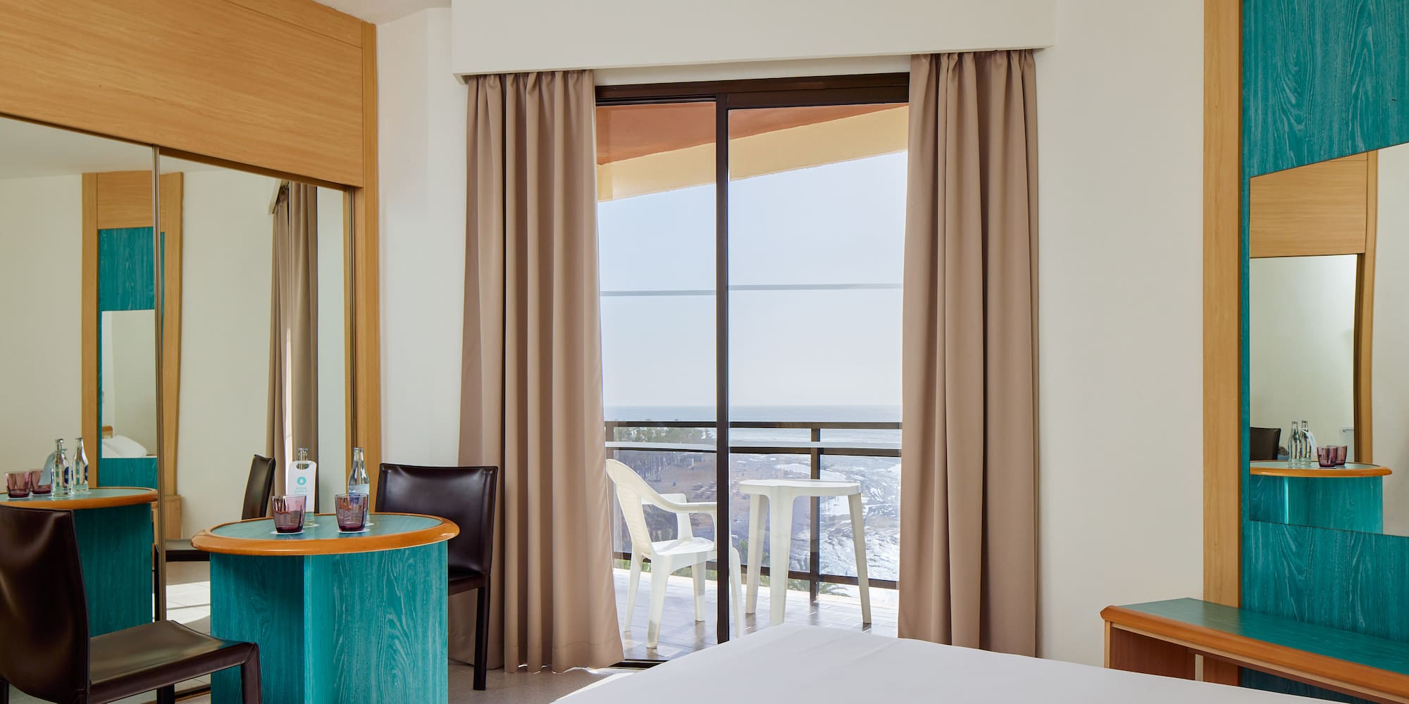 a room with a bed and a table and chairs