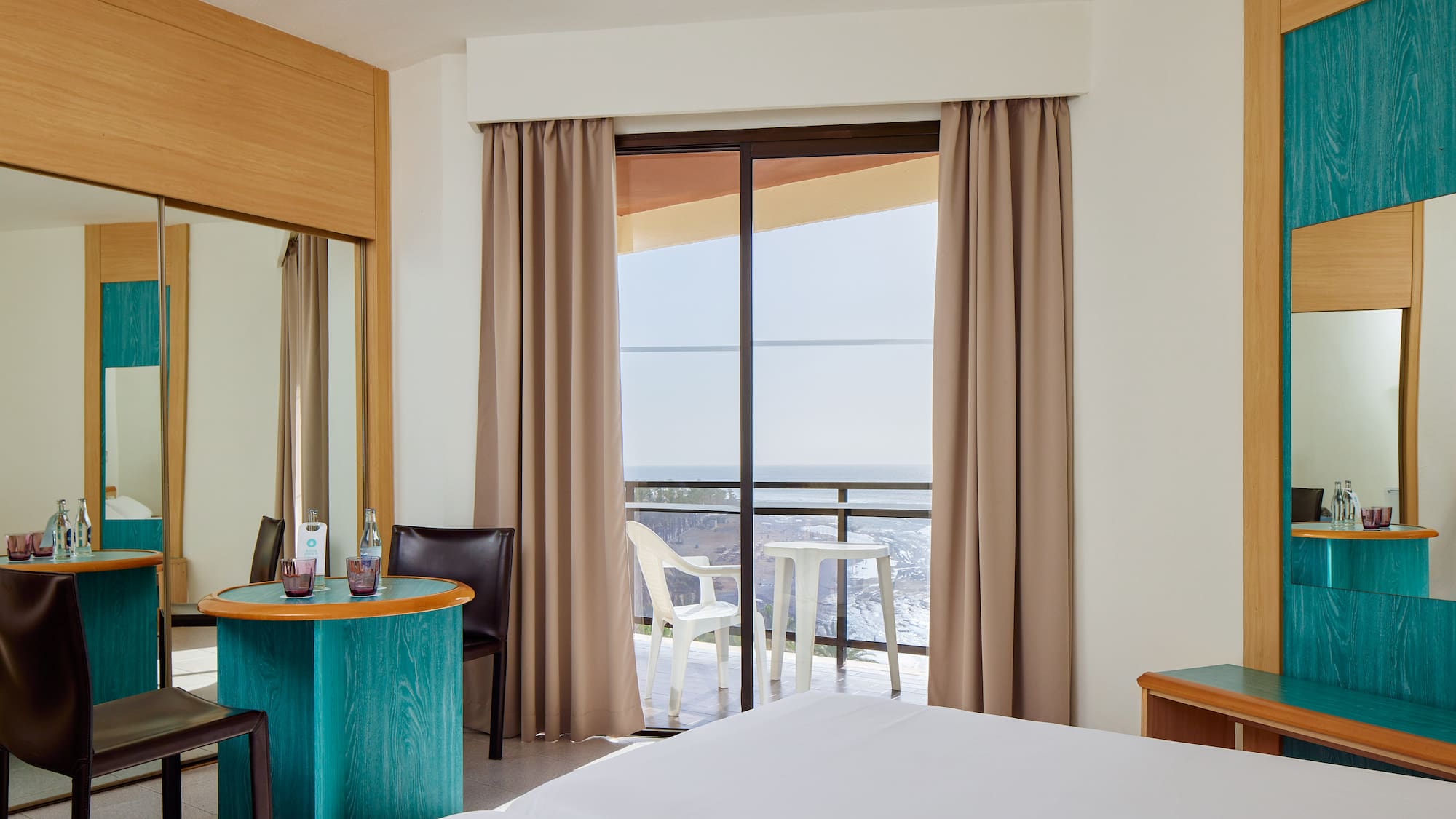 a room with a bed and a table and chairs