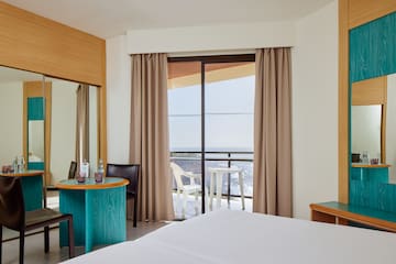 a room with a bed and a table and chairs