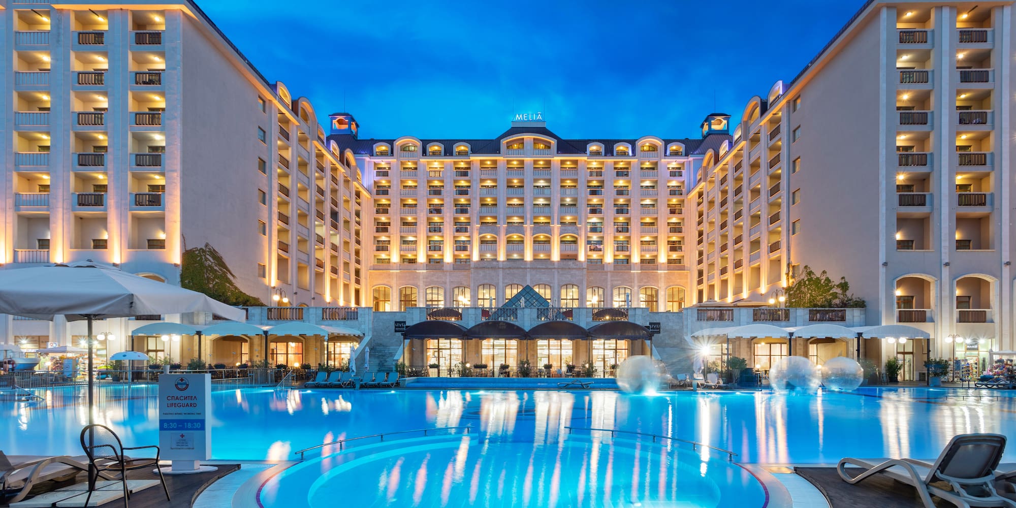 a large hotel with a pool and a large building
