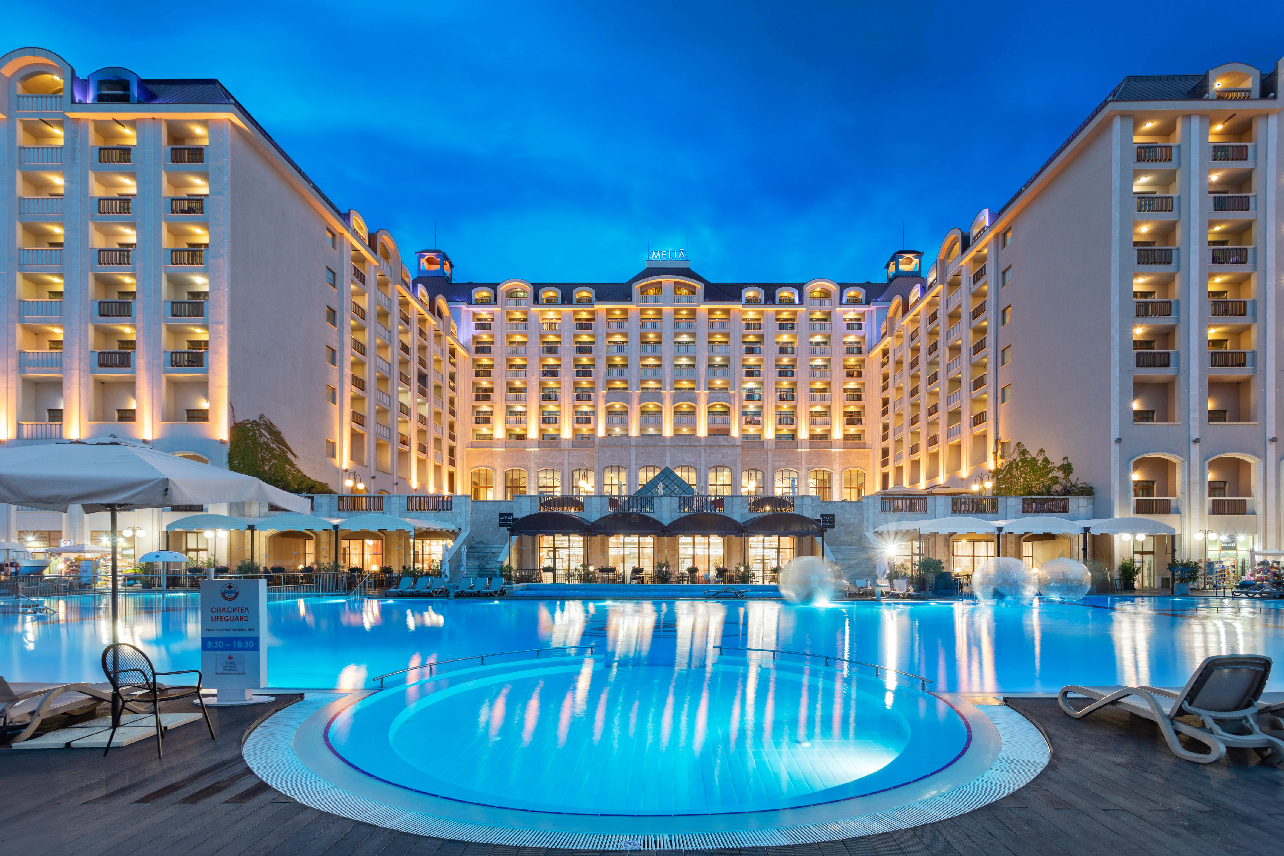 a large hotel with a pool and a large building