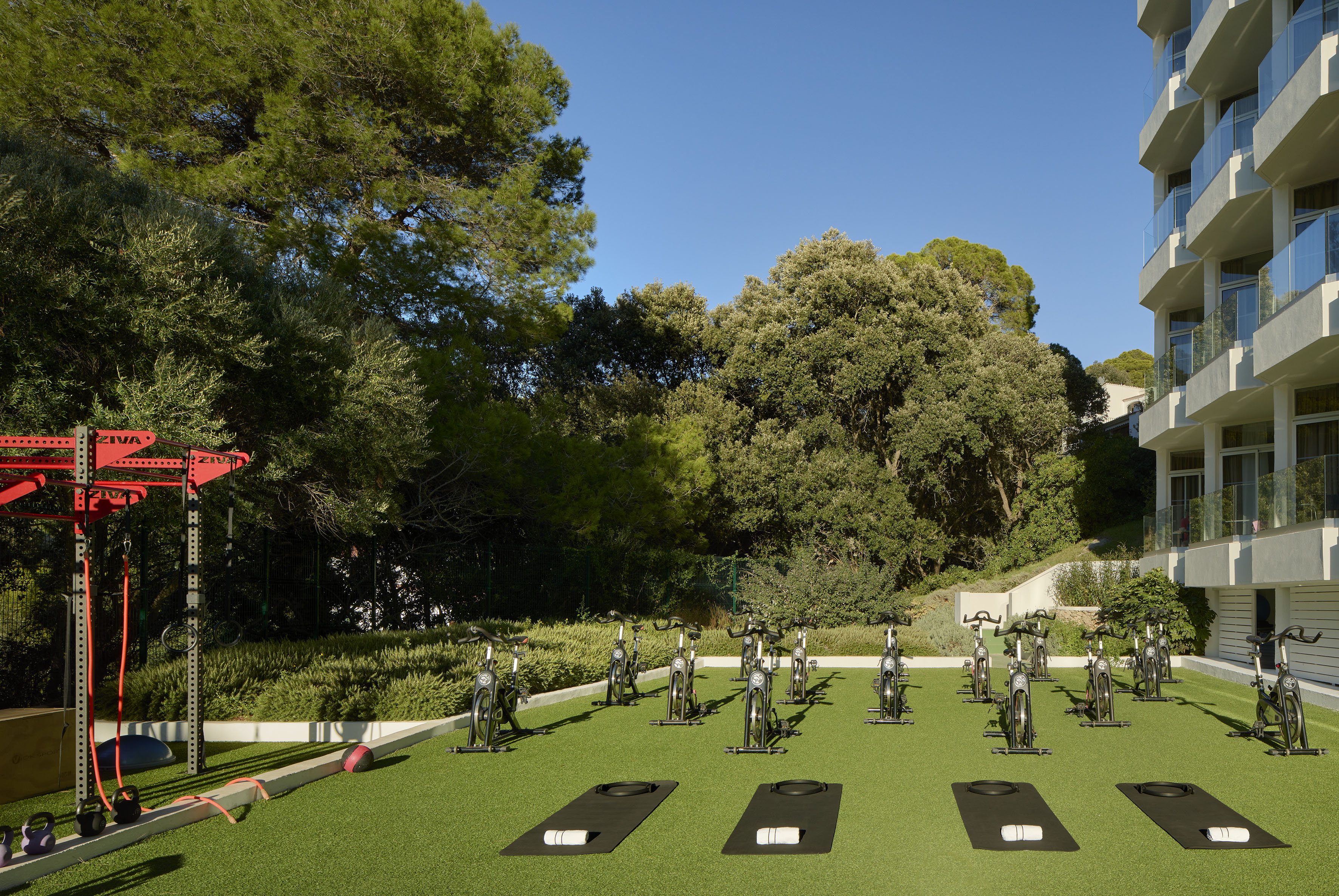 Outdoor resort gym with spin bikes, yoga mats, and ZIVA fitness equipment.