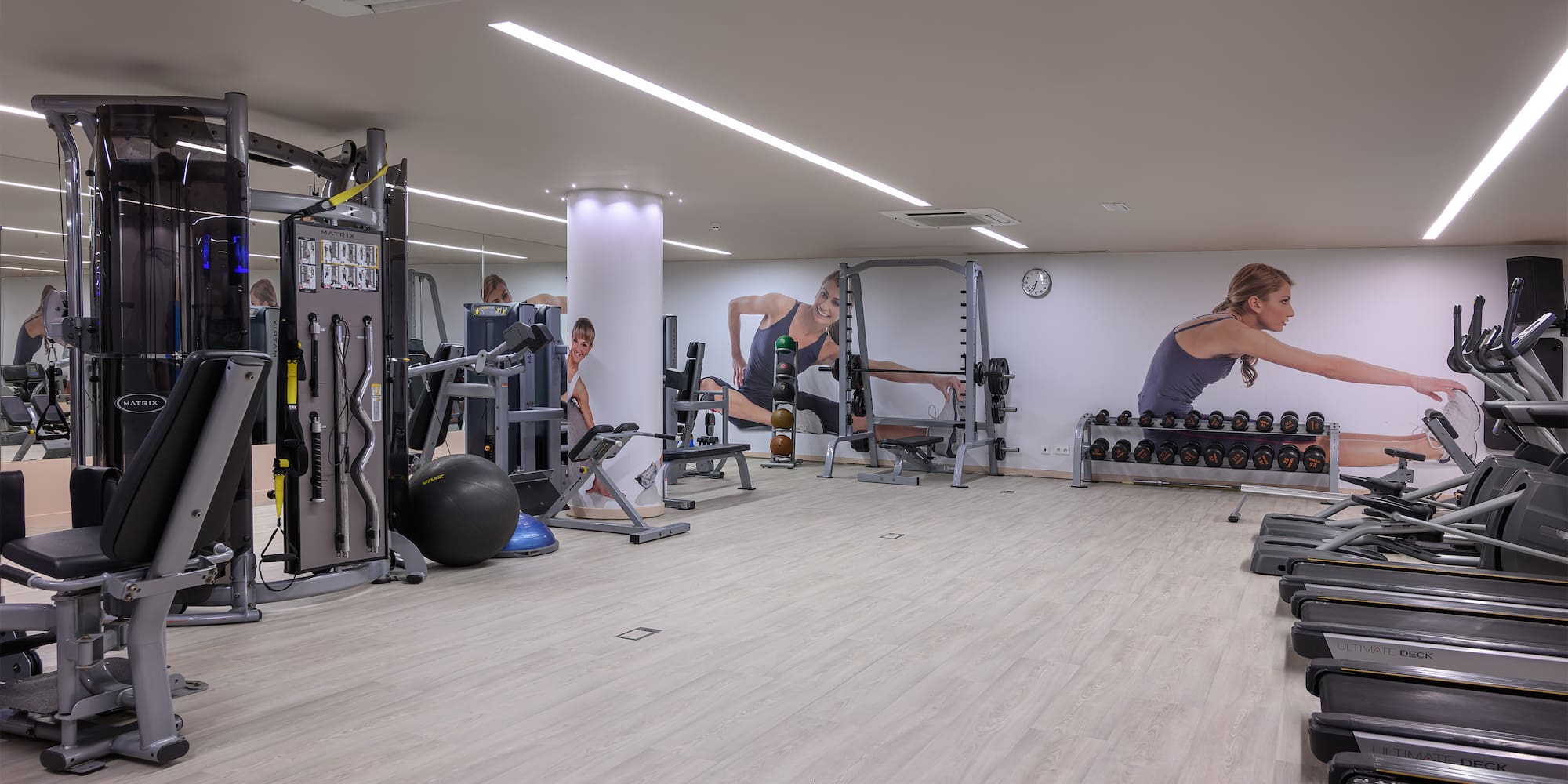 a large room with gym equipment and people in the background