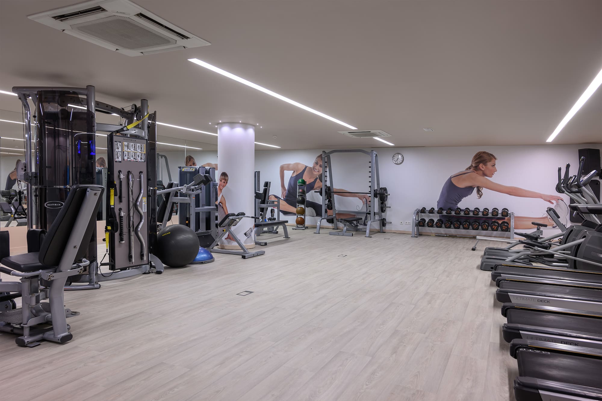 a large room with gym equipment and people in the background