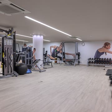 a large room with gym equipment and people in the background