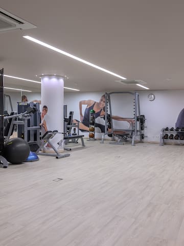 a large room with gym equipment and people in the background