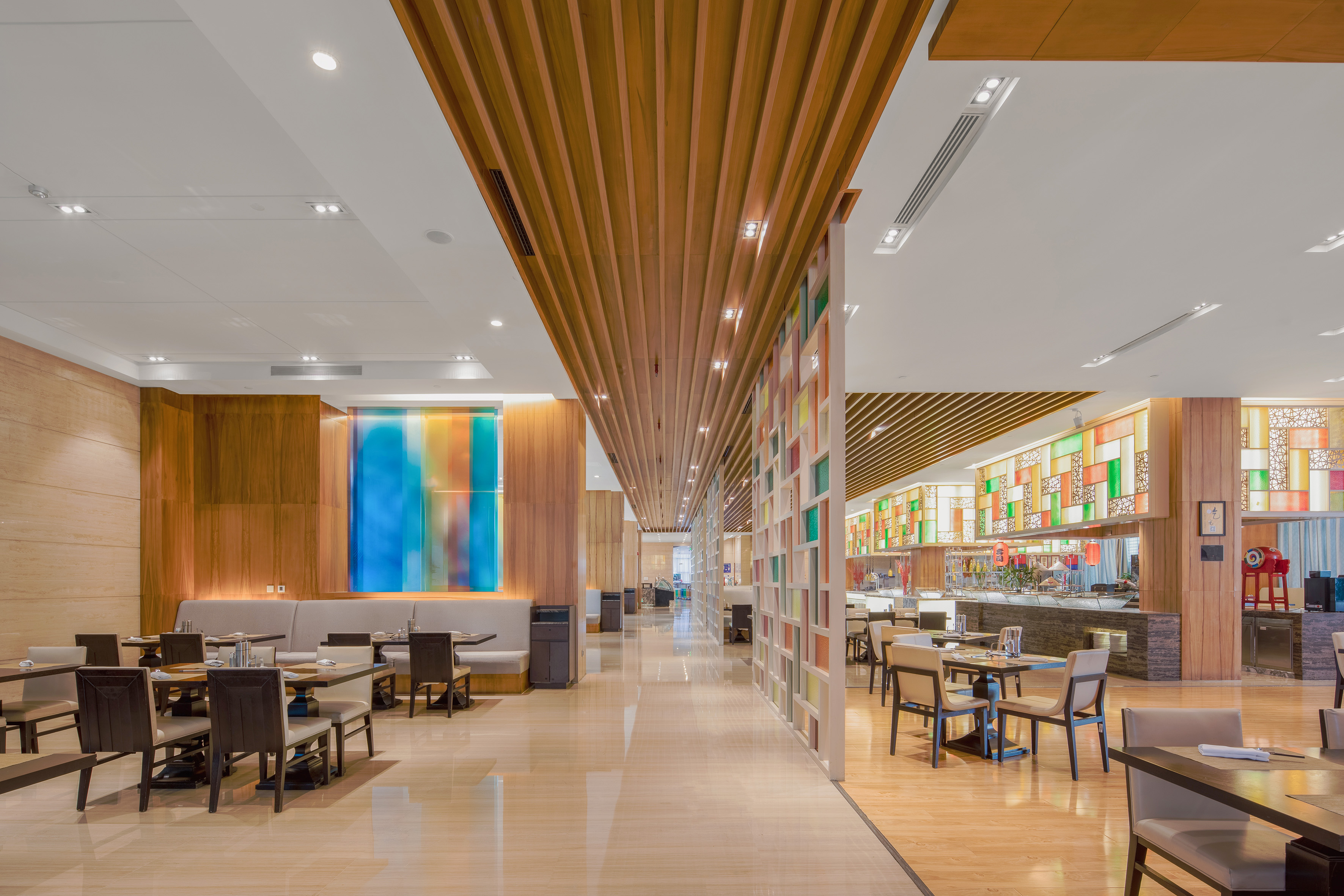 Spacious modern restaurant interior with buffet, wood accents, and colorful details.