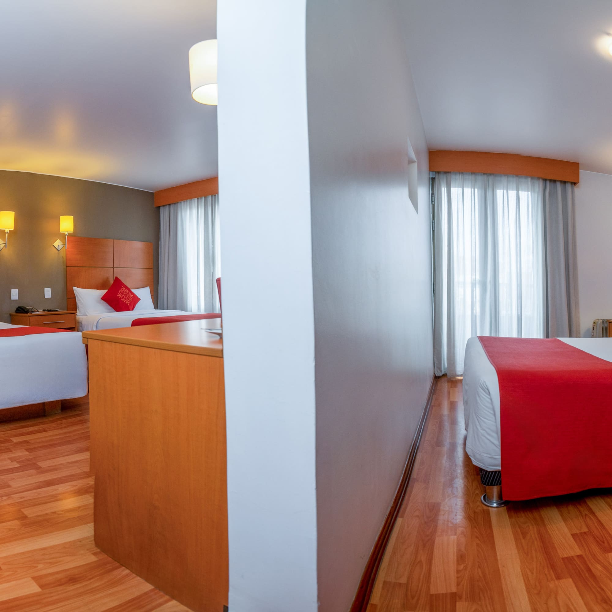 a room with two beds and a wood floor