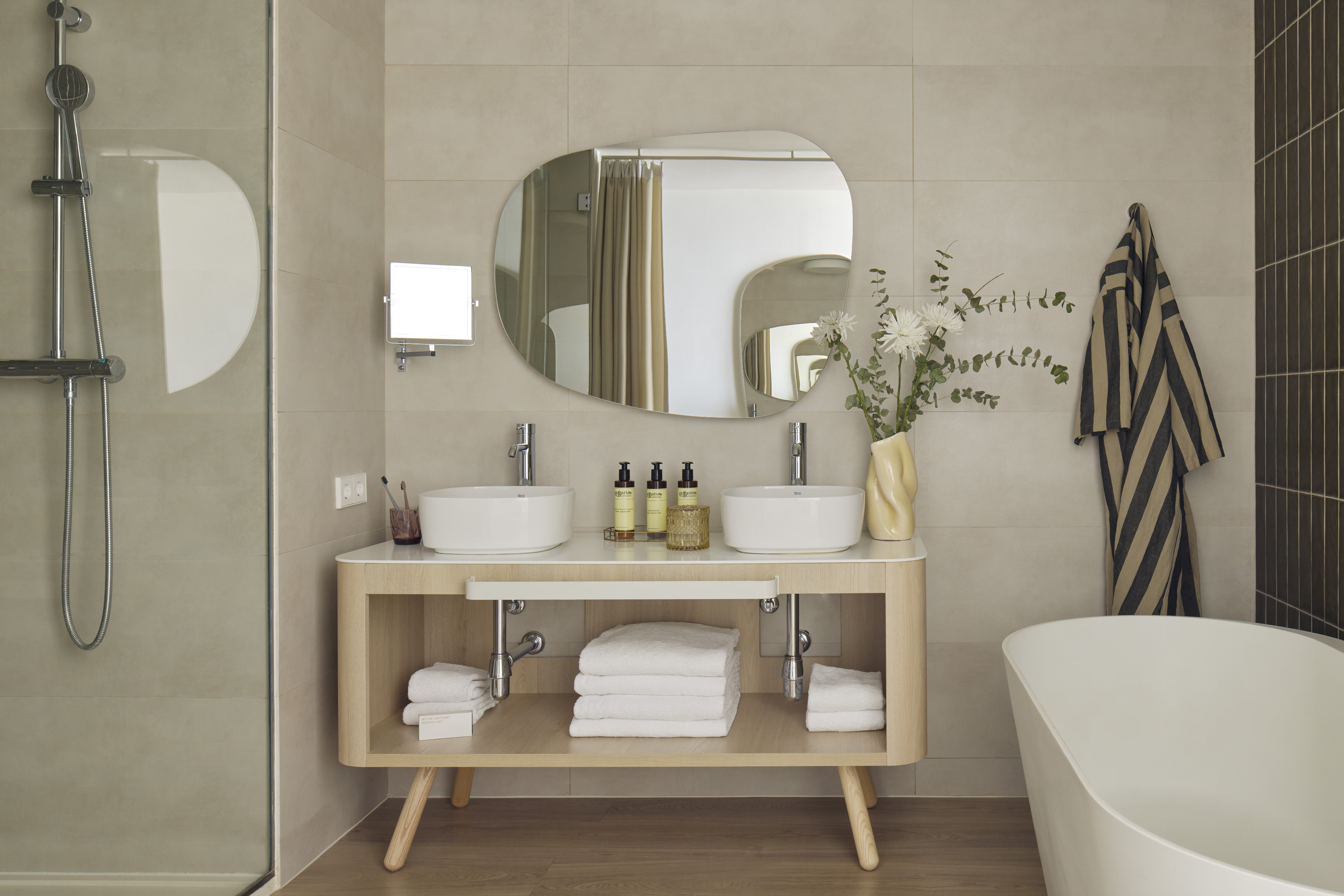 Modern bathroom with double vanity, vessel sinks, shower, and bathtub.