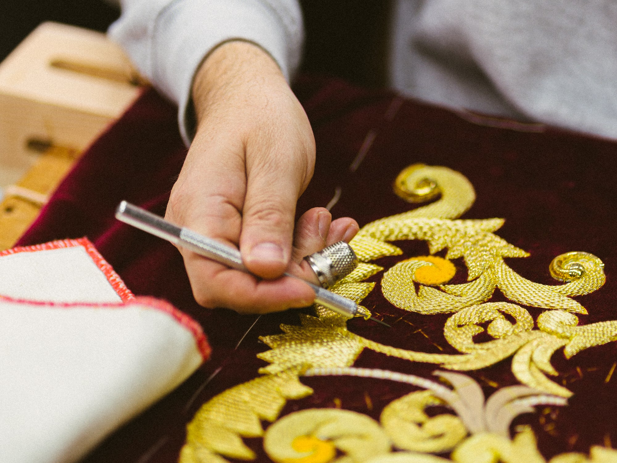 a person drawing a design on a red cloth