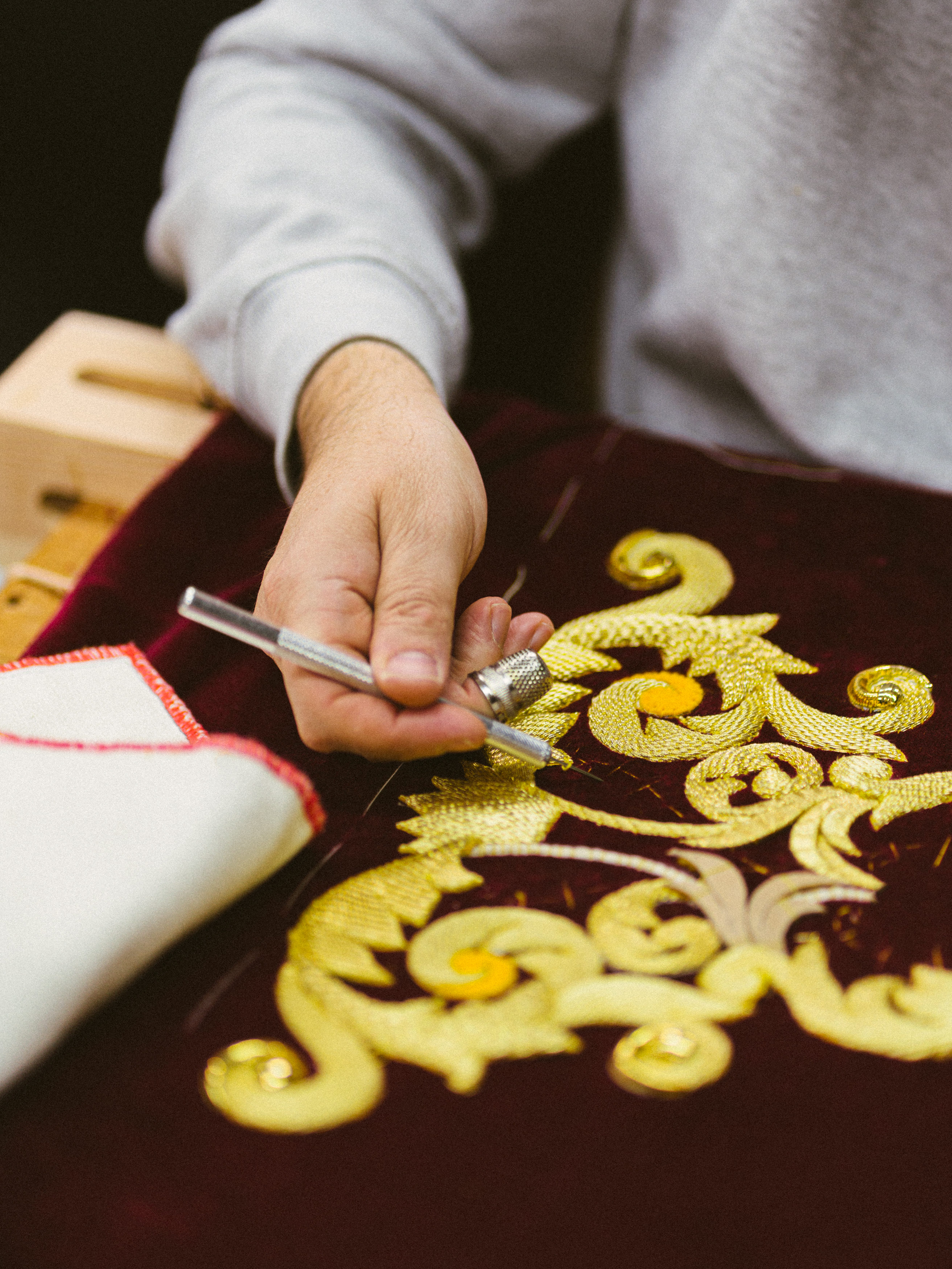 a person drawing a design on a red cloth