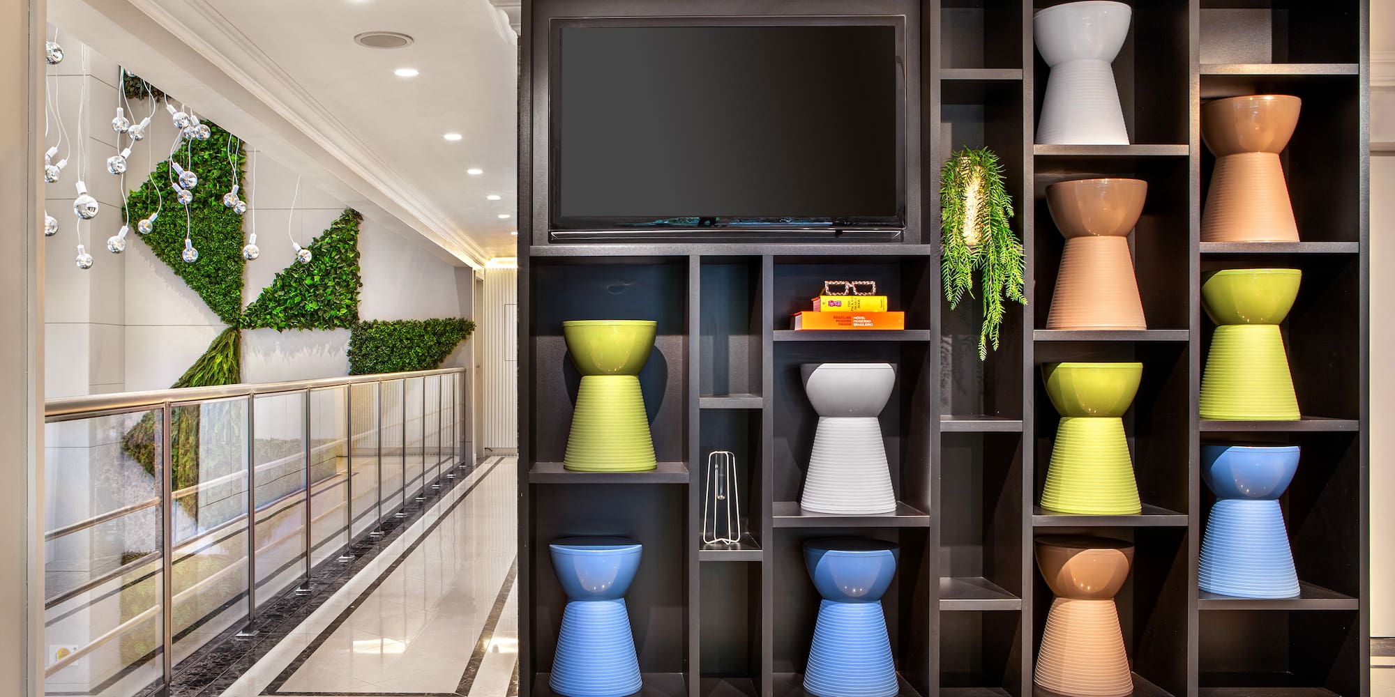 a shelf with colorful vases and a tv