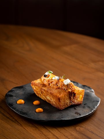 a piece of bread with toppings on a black plate