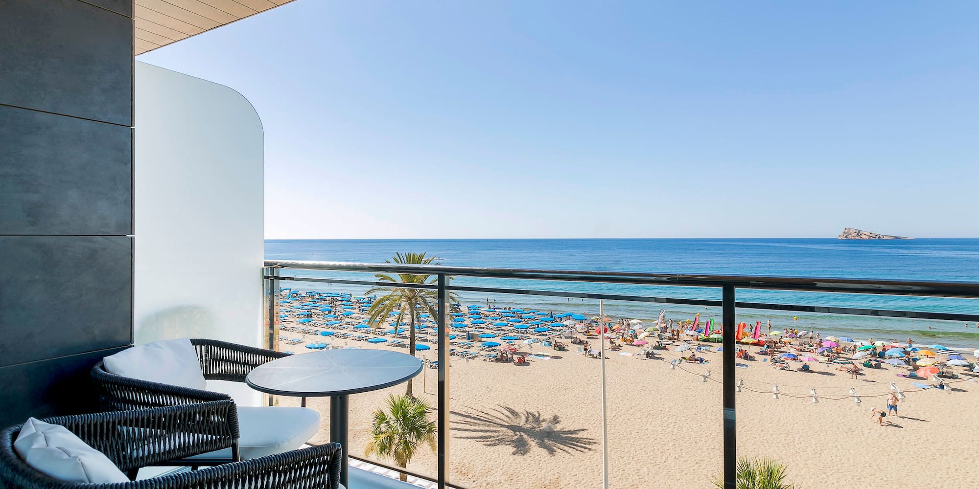 a balcony with a beach and a view of the ocean