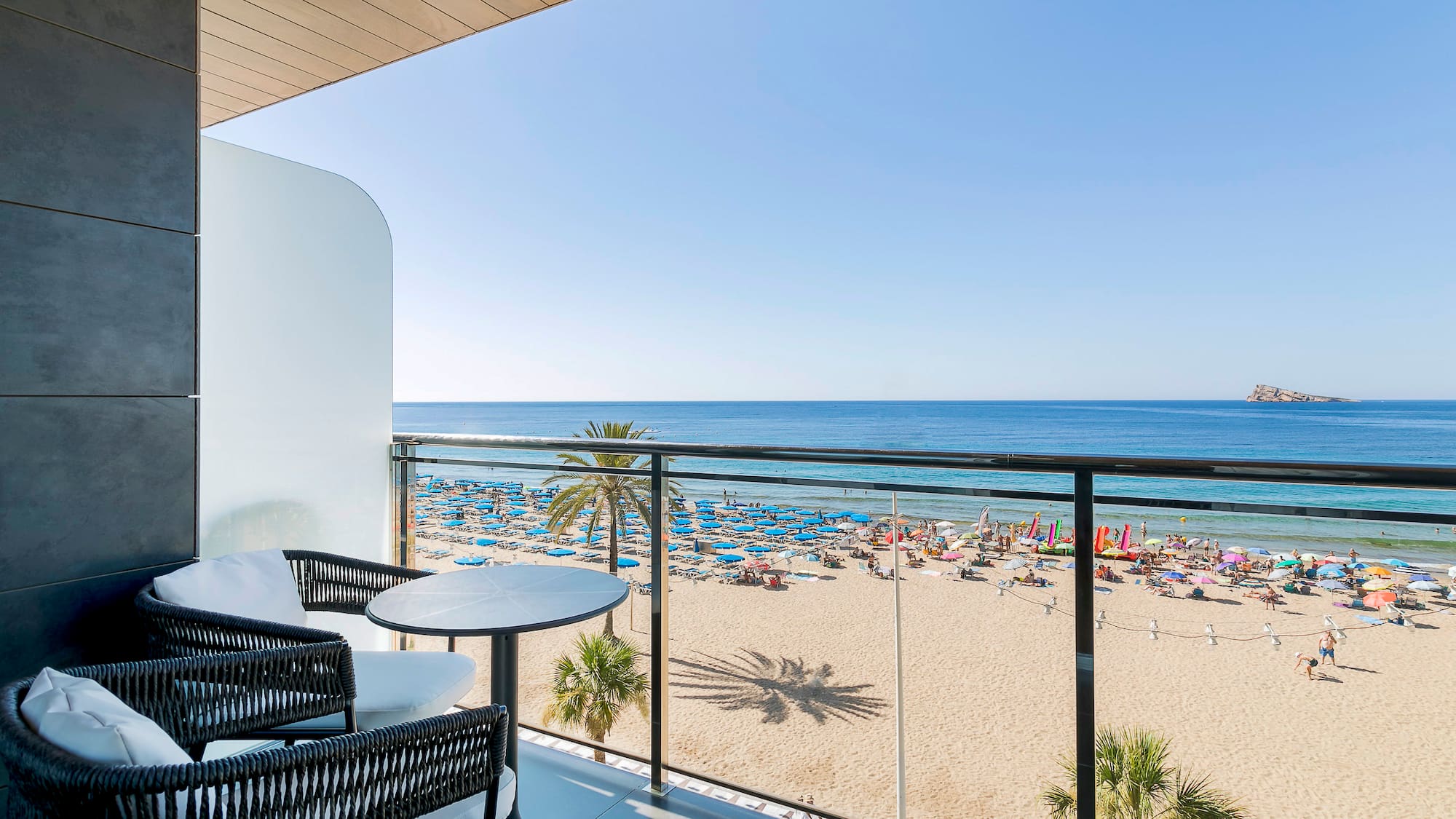 a balcony with a beach and a view of the ocean